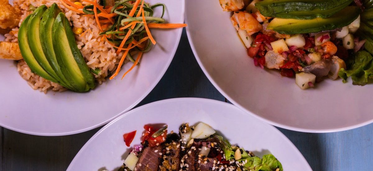 Three flavorful dishes featuring seafood and avocado, plated creatively for a delightful meal.
