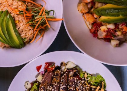 Three flavorful dishes featuring seafood and avocado, plated creatively for a delightful meal.